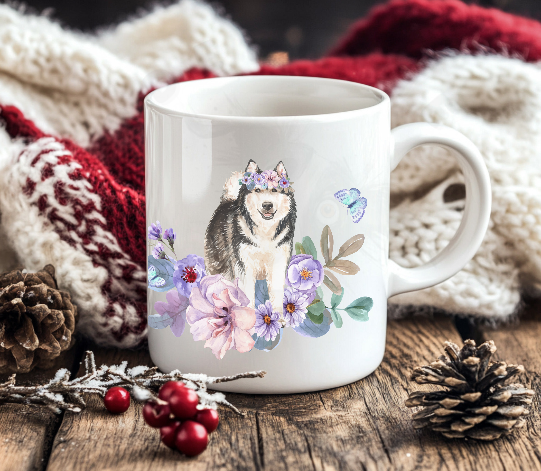 alaskan malamute in flowers mug in front of a red and white christmas blanket with holly berries and pine cones
