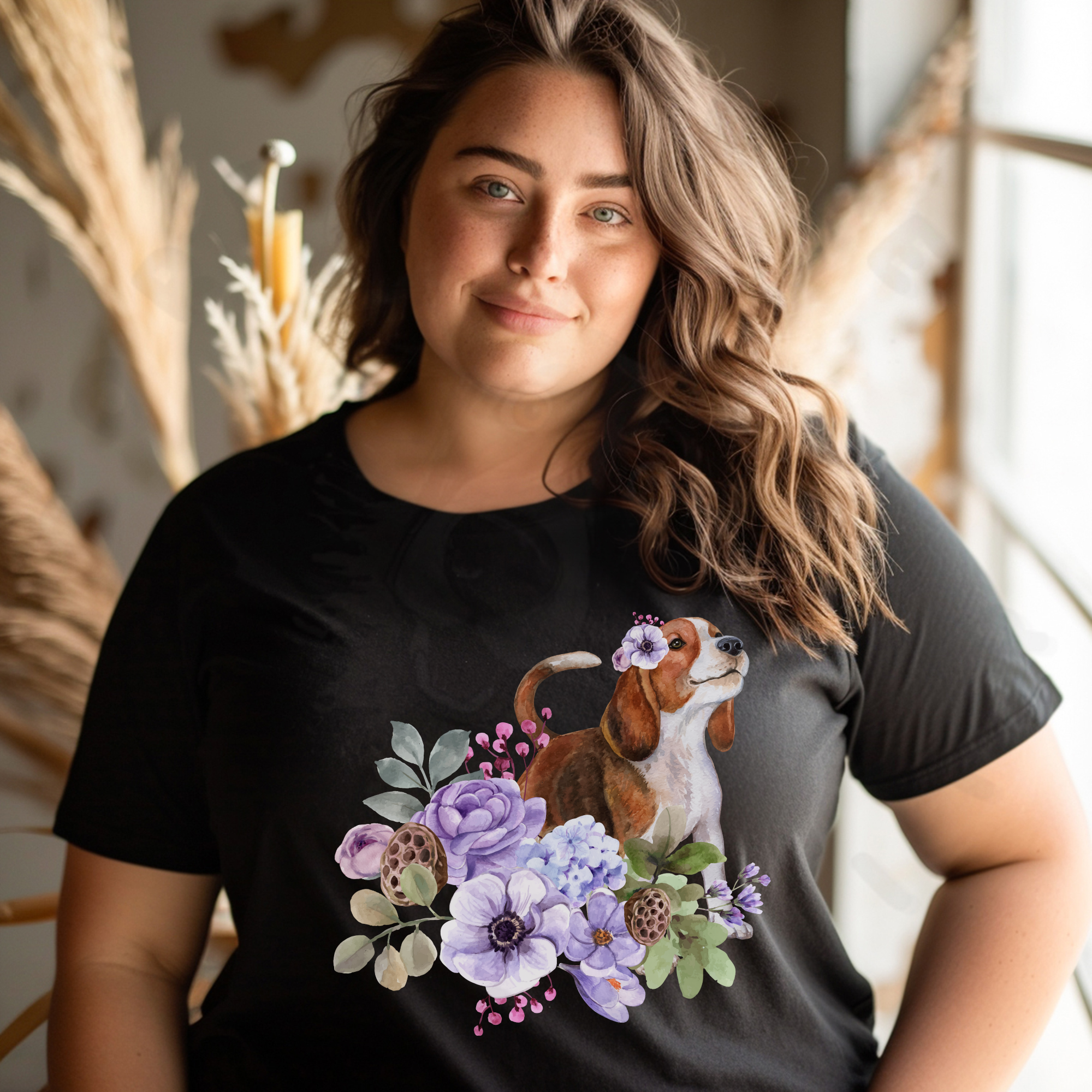 a woman wearing a black beagle in flowers tee in front of a boho background