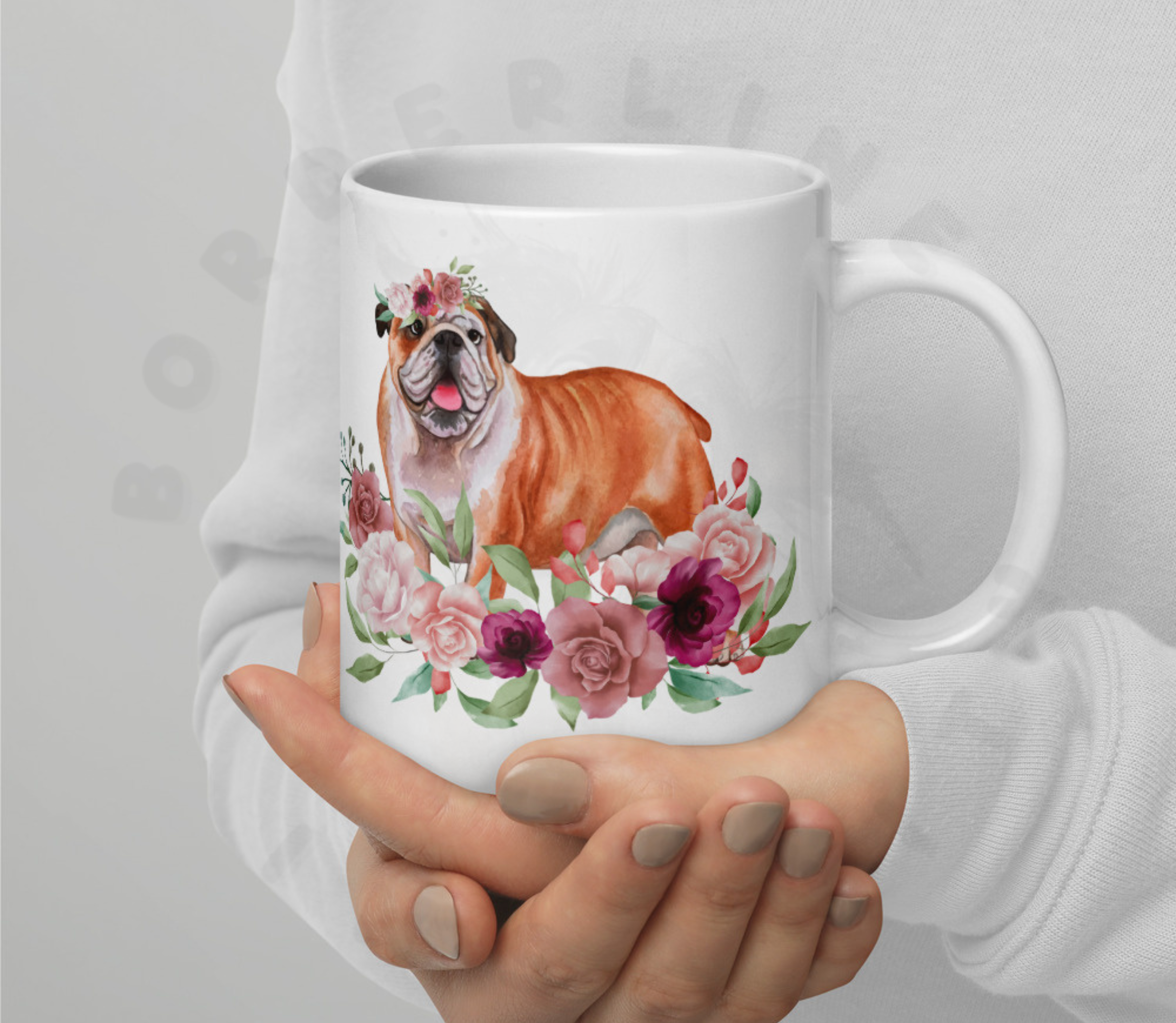 English bulldog in flowers mug held by someone wearing a white sweatshirt