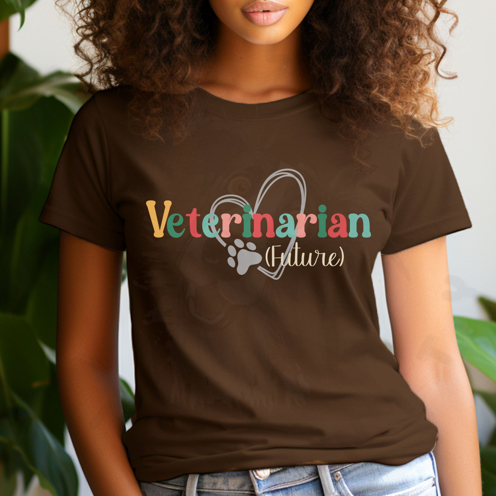 a woman standing in front of plants wearing a brown future veterinarian tee with a heart and paw print