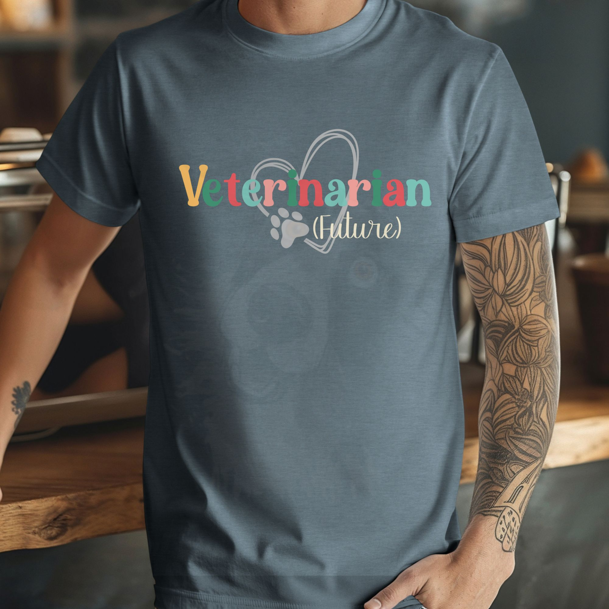 a man in a coffee shop wearing a heather slate future veterinarian tee with a heart and paw print