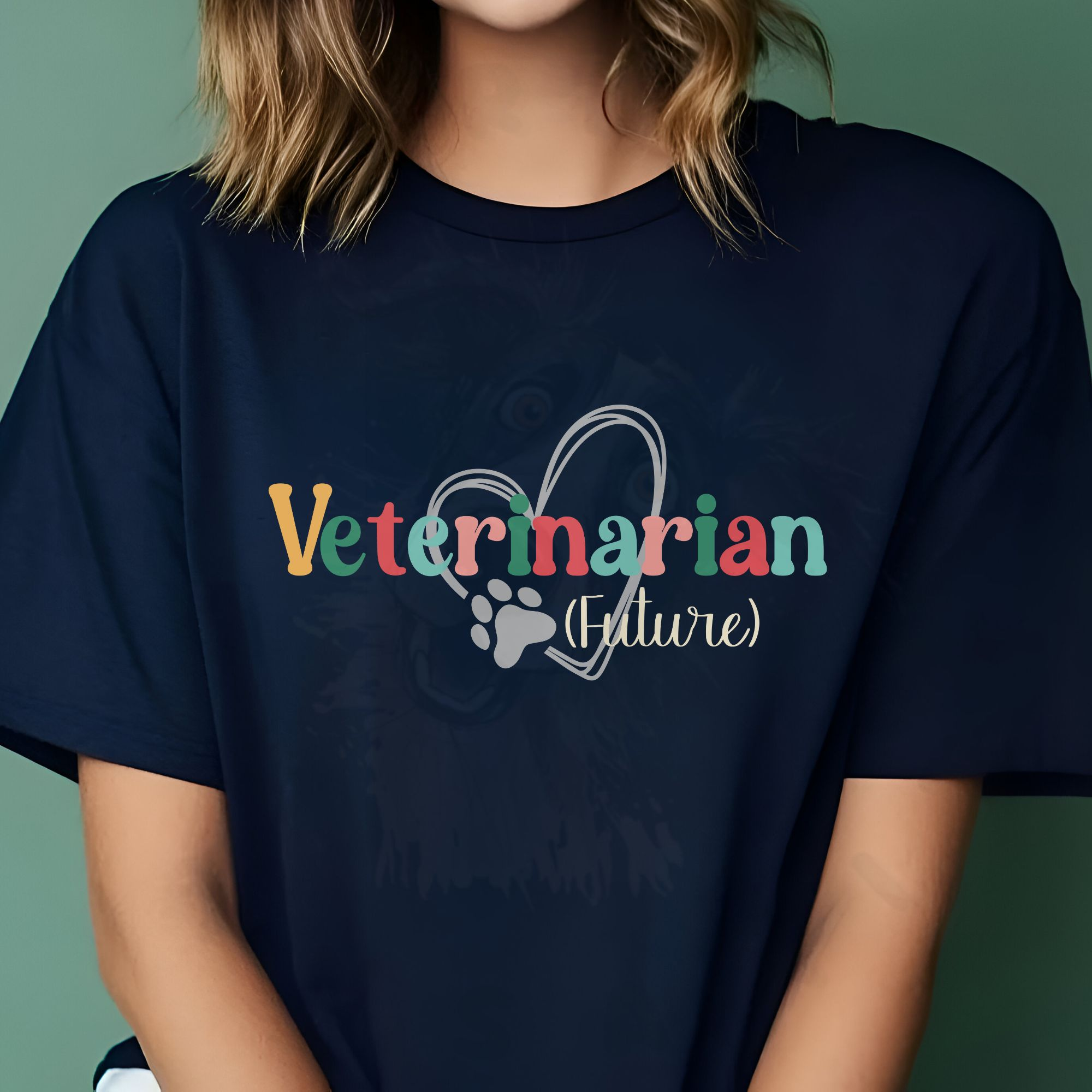 a woman sitting in front of a dark mint background wearing a future veterinarian tee with a heart and paw print