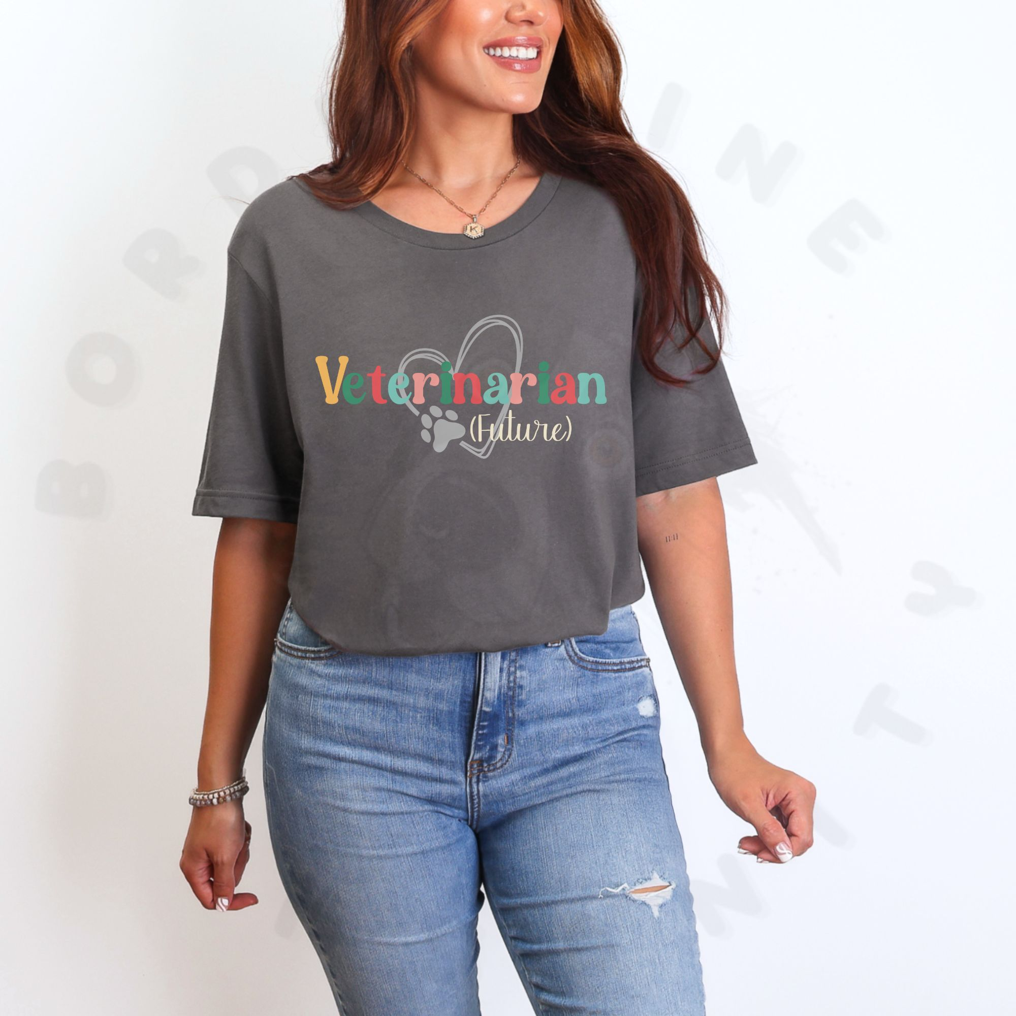 a woman standing in front of a white background wearing an asphalt future veterinarian tee with a heart and paw print
