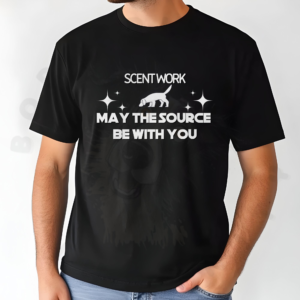 a man standing in front of a white background with his left hand in his pocket wearing a black scent work may the source be with you tee