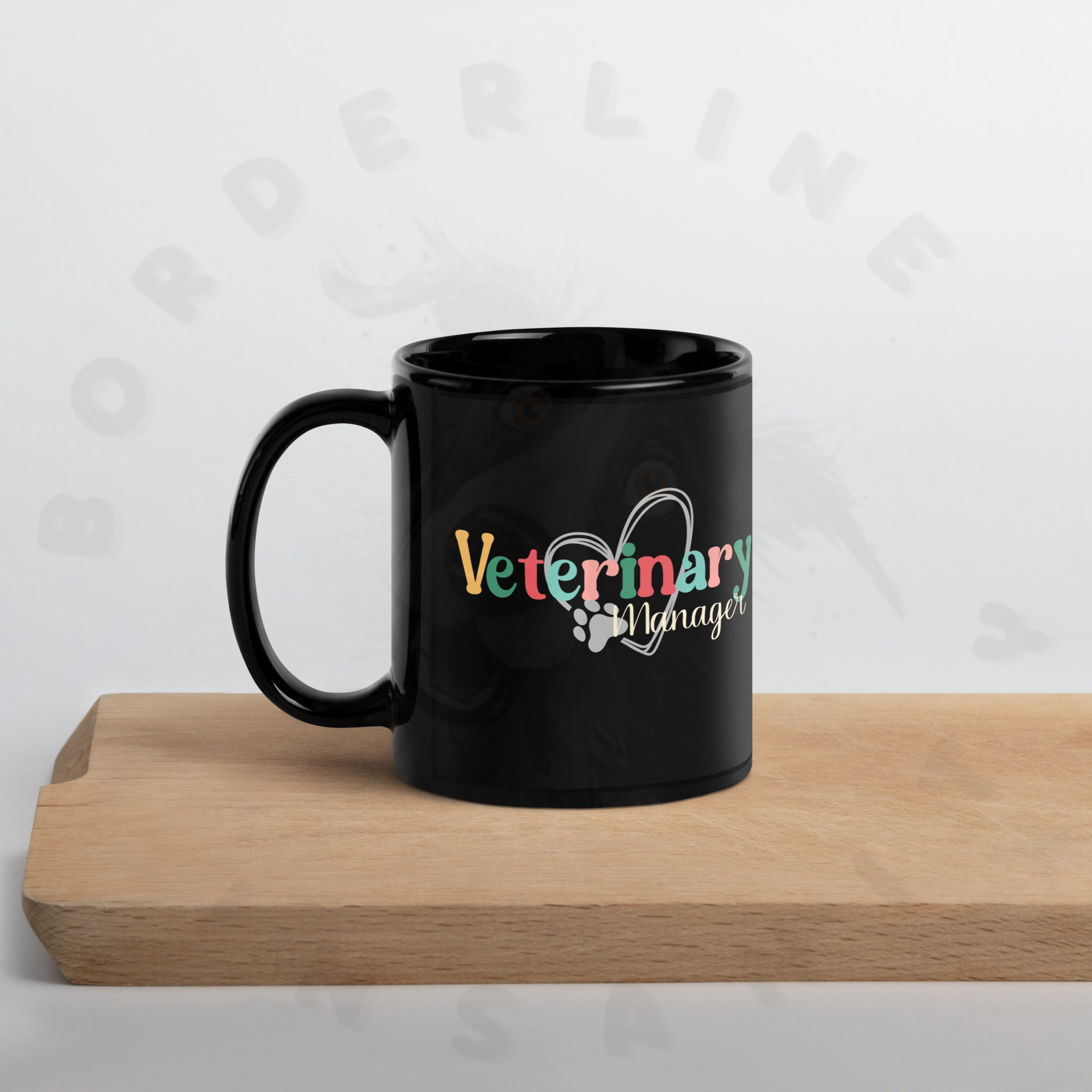 11oz black ceramic veterinary manager mug on a cutting board