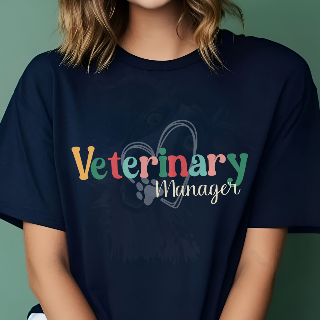 a woman sitting in front of a dark mint background wearing a veterinary manager tee with a heart and paw print