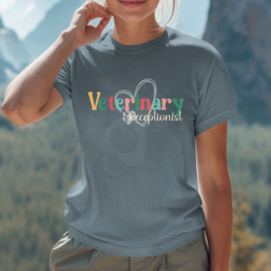 a woman standing in front of distant mountains wearing a heather slate veterinary receptionist tee with a heart and paw print