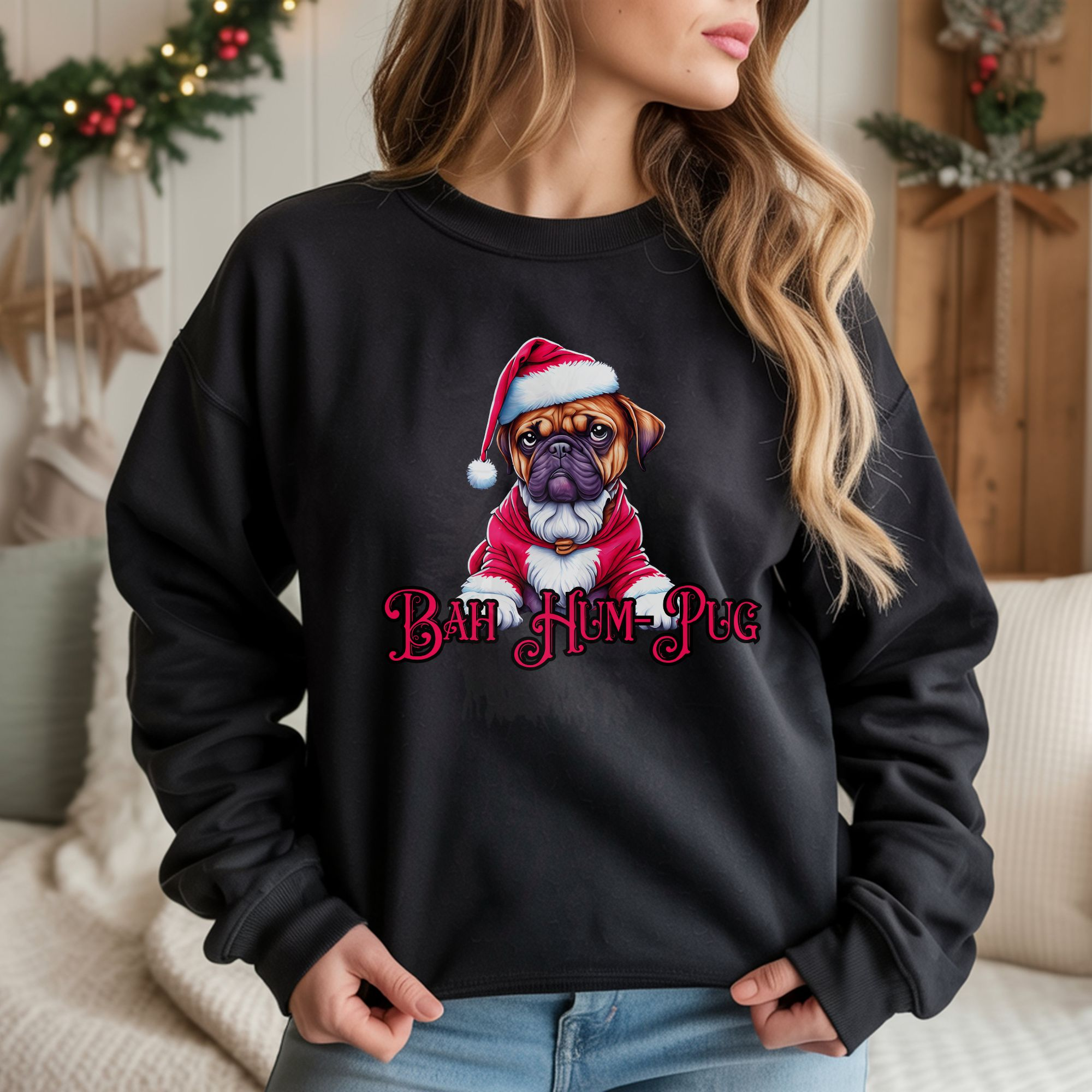 a woman standing in a room decorated for christmas wearing a black sweatshirt that says bah hum-pug below a graphic of a grumpy pug wearing a santa suit