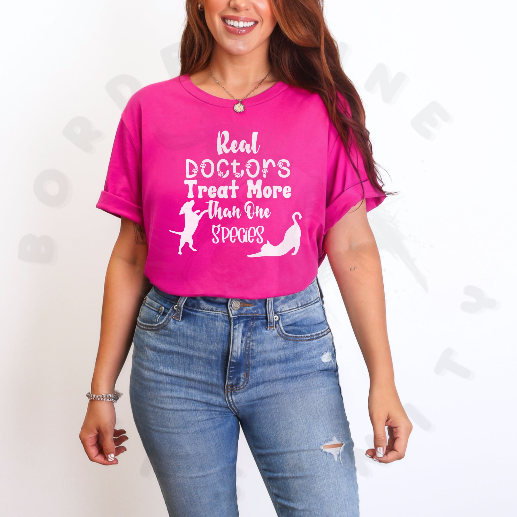 a woman standing in front of a white background wearing a berry pink t-shirt that says real doctors treat more than one species in various fonts