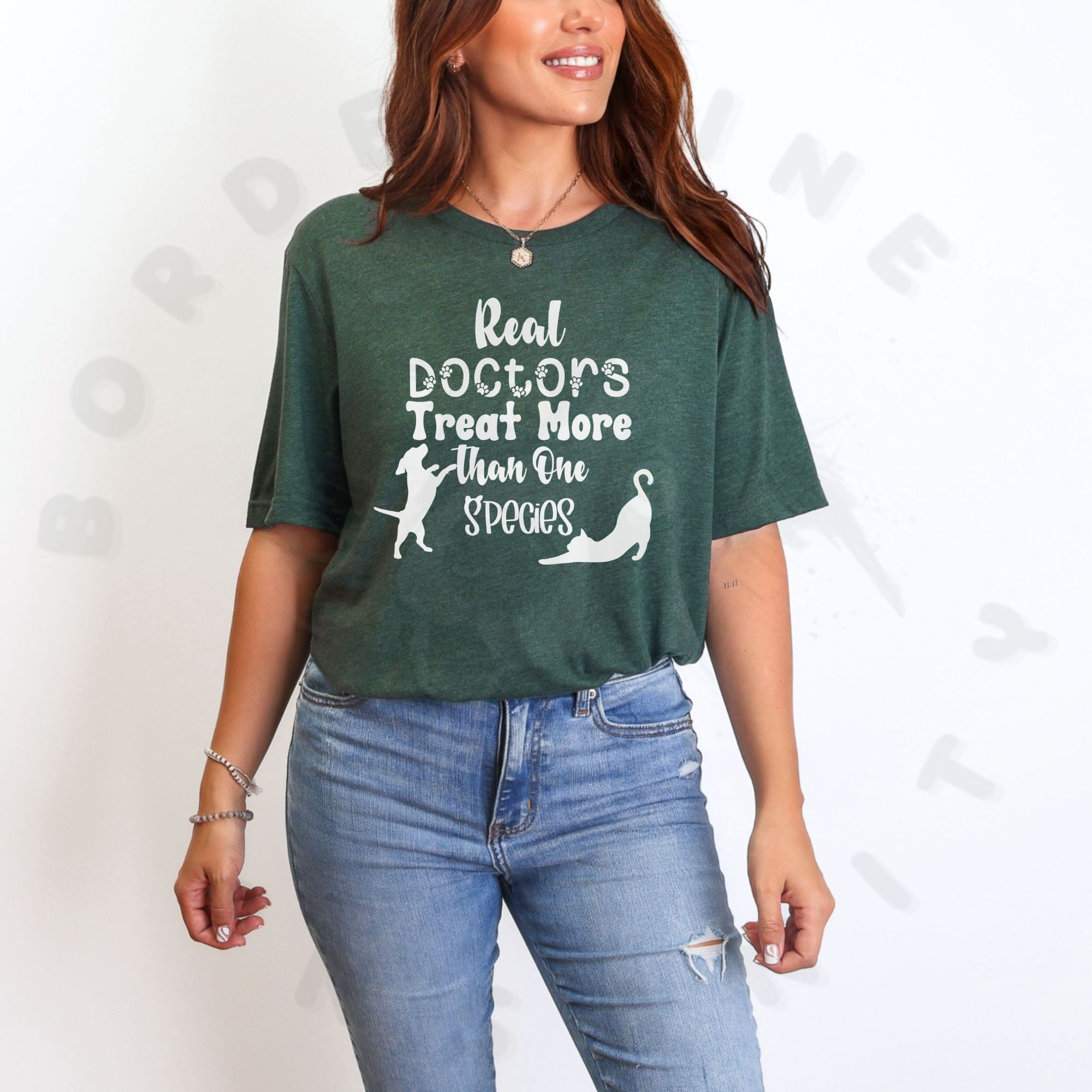 a woman standing in front of a white background wearing a heather forest t-shirt that says real doctors treat more than one species in various fonts