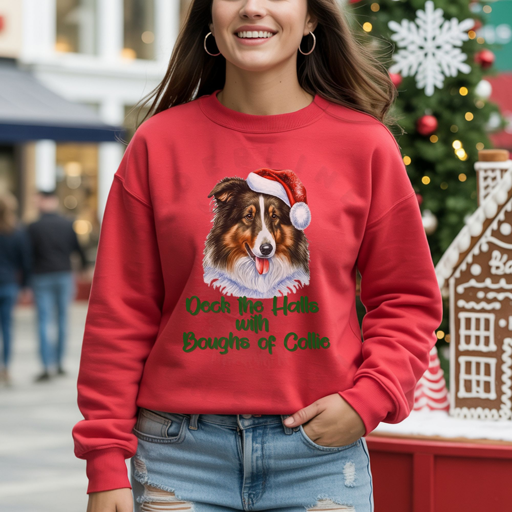 a woman standing outside among christmas decorations wearing a red sweatshirt with a rough collie in a santa hat and the words deck the halls with boughs of collie