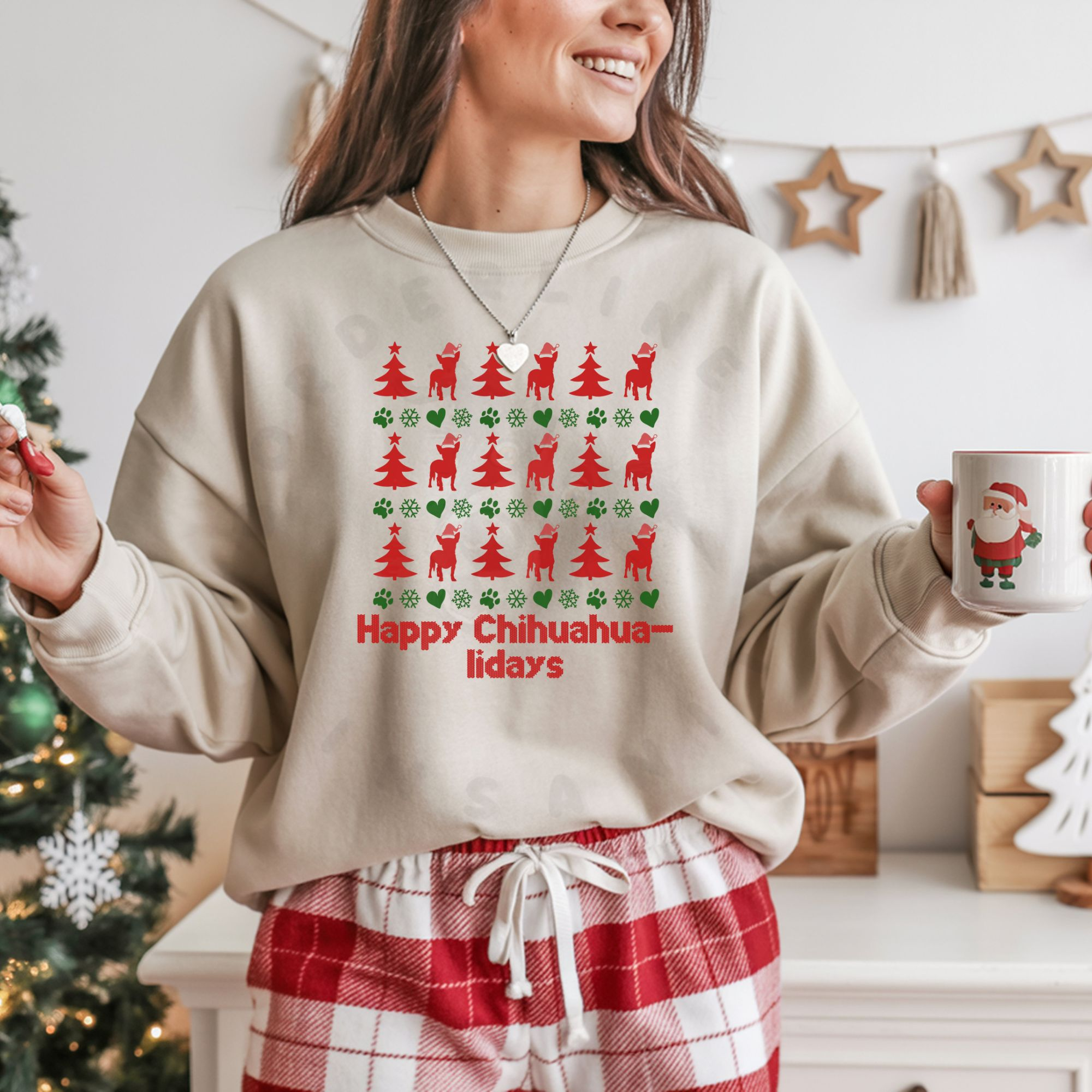 a woman in red and white plaid pajama pants in a room decorated for christmas wearing a sand sweatshirt designed ugly christmas sweater style with rows of red christmas trees, green snowflakes, and chihuahuas wearing santa hats.
