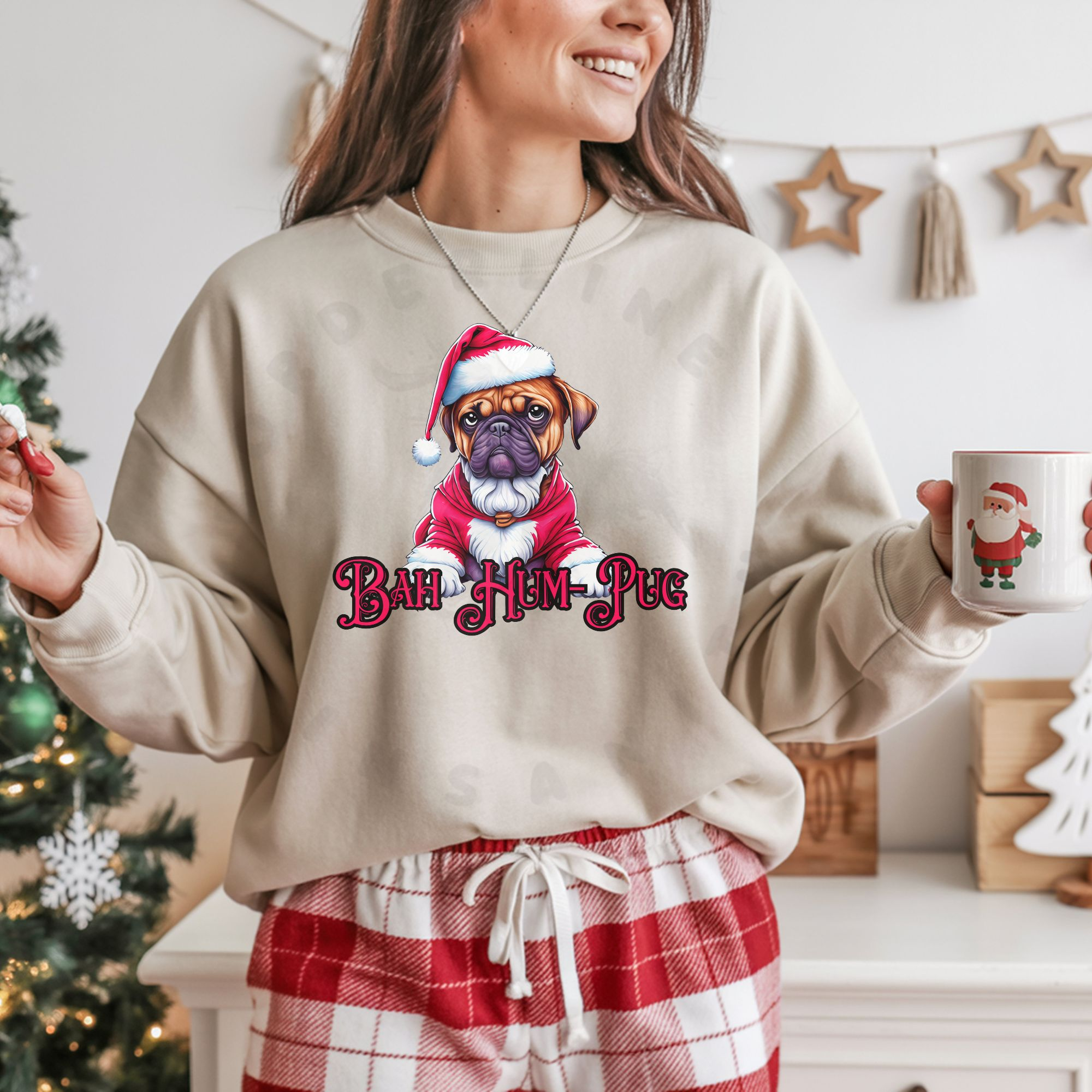 a woman standing in a room decorated for christmas wearing a sand sweatshirt that says bah hum-pug below a graphic of a grumpy pug wearing a santa suit