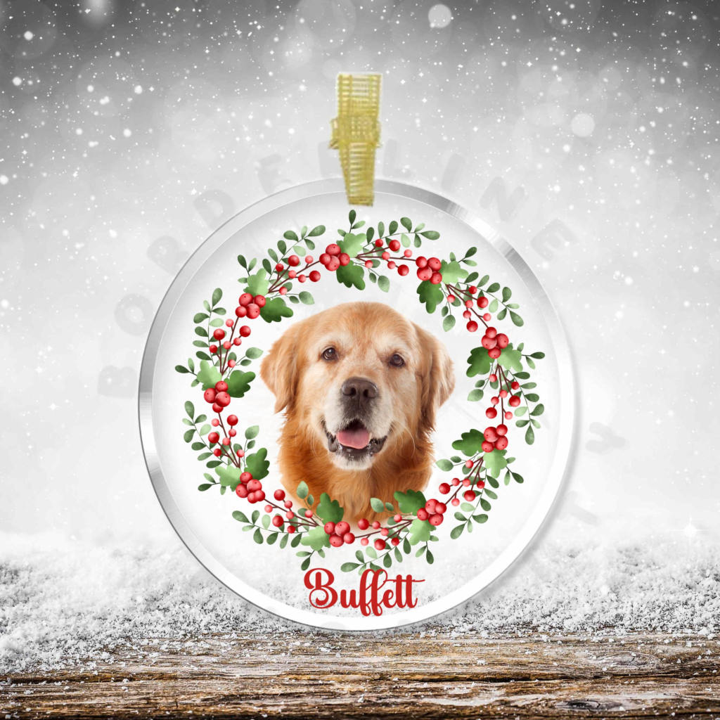 a glass ornament with a dog's face and a watercolor holly and berries wreath, and the dog's name