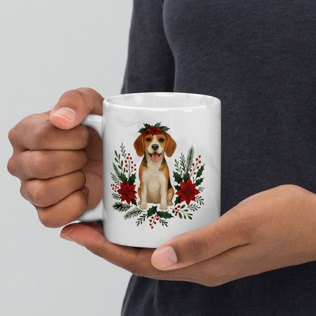 Hands holding Beagle Christmas coffee mug with festive floral wreath design and holiday greenery