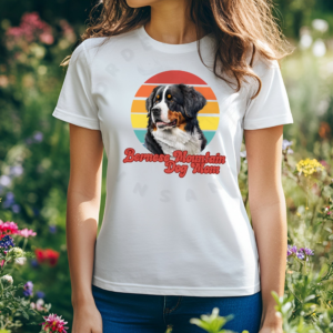 a woman wearing a white tee featuring a retro sunset design with a bernese mountain dog and the words bernese mountain dog mom in retro script