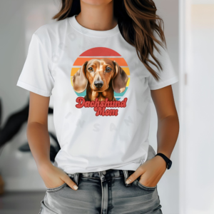 a woman wearing a white tee featuring a retro sunset design with a dachshund and the words dachshund mom in retro script