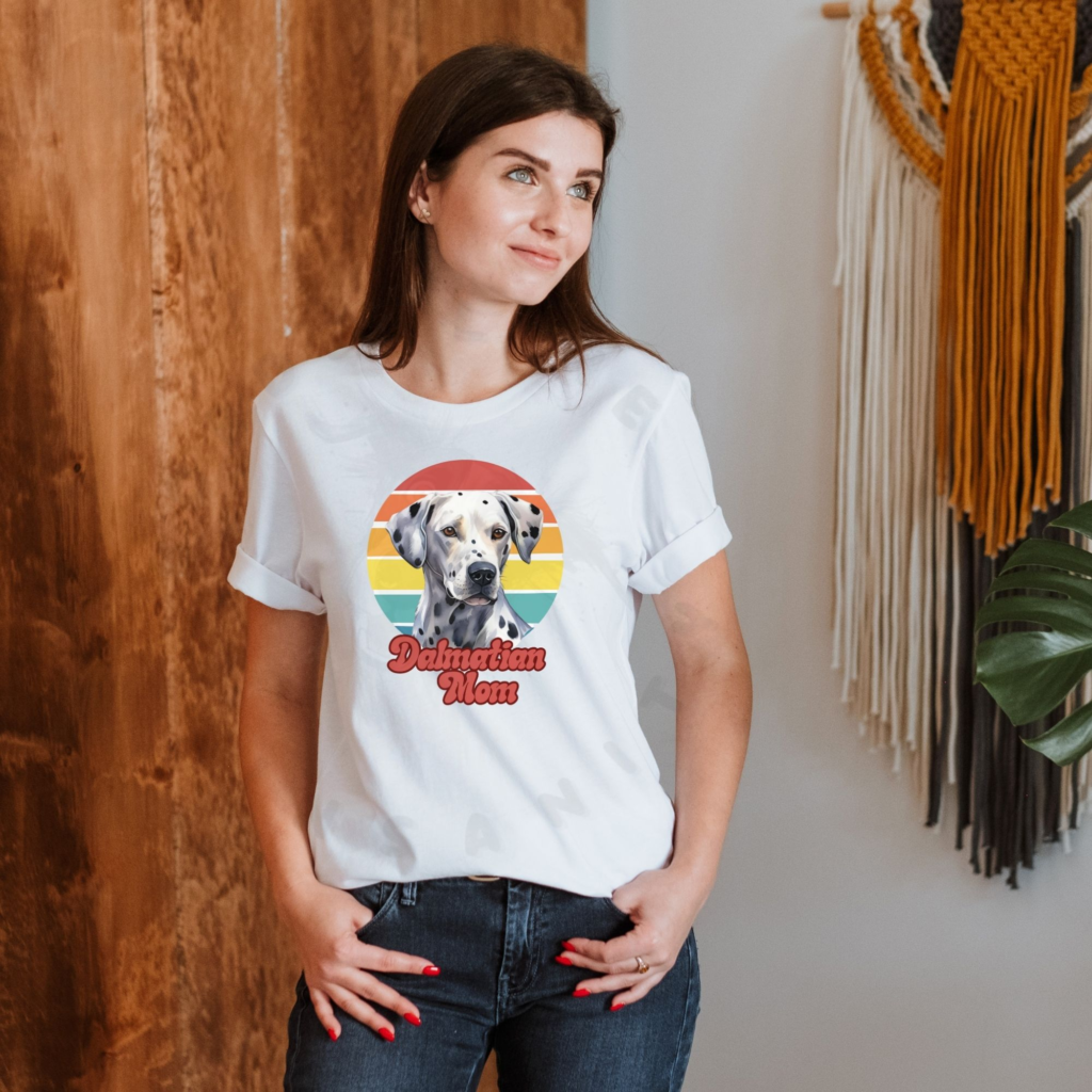 a woman wearing a white tee featuring a retro sunset design and a dalmatian with the words dalmatian mom in retro script