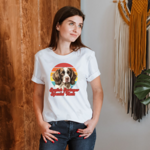 a woman wearing a white tee featuring a retro sunset design with an english springer spaniel and the words english springer spaniel mom in retro script