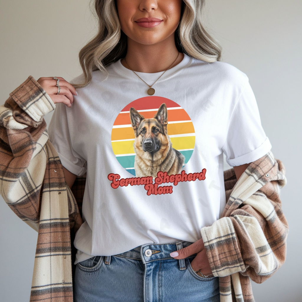 a woman wearing a white tee featuring a retro sunset with a german shepherd and the words german shepherd mom