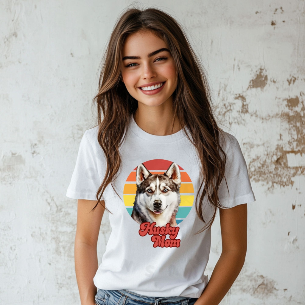 a woman wearing a white tee featuring a retro sunset design with a husky and the words husky mom in retro script