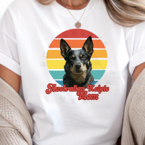 a woman wearing a white tee with a retro sunset design featuring an australian kelpie and the words australian kelpie mom in retro script