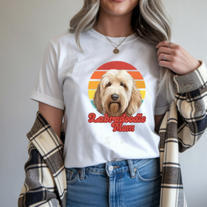 a woman wearing a white tee with a retro sunset design and a labradoodle with the words labradoodle mom in retro script