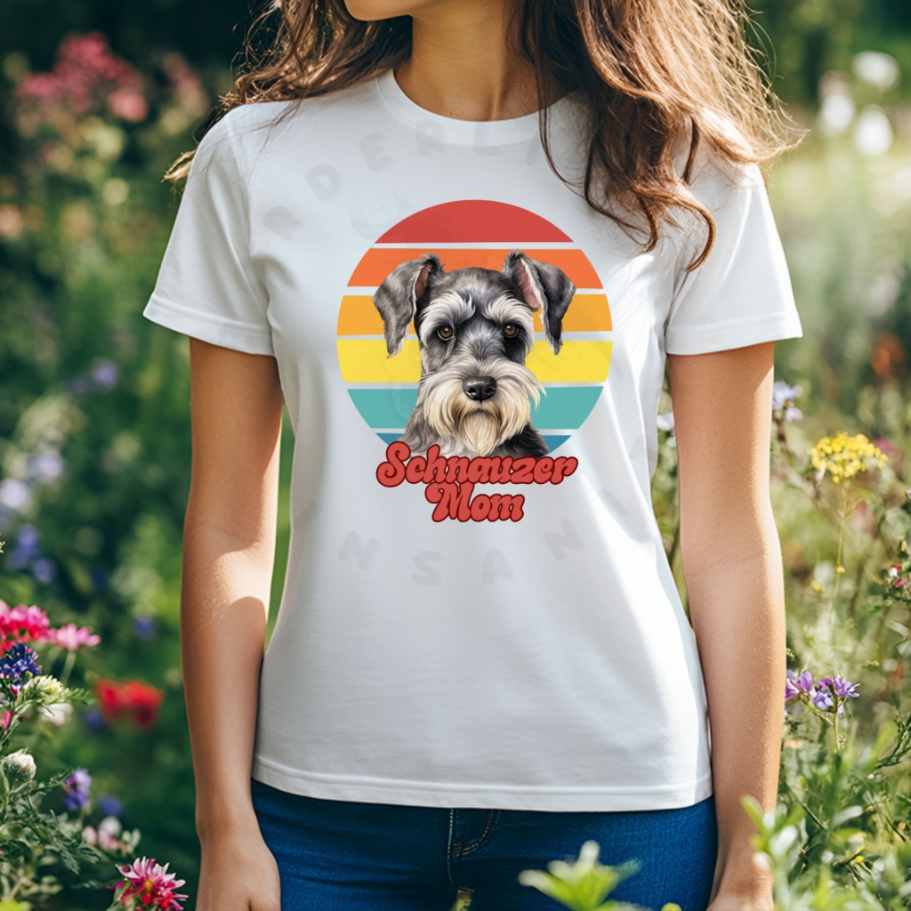 a woman wearing a white tee featuring a retro sunset design with a schnauzer and the words schnauzer mom in retro script