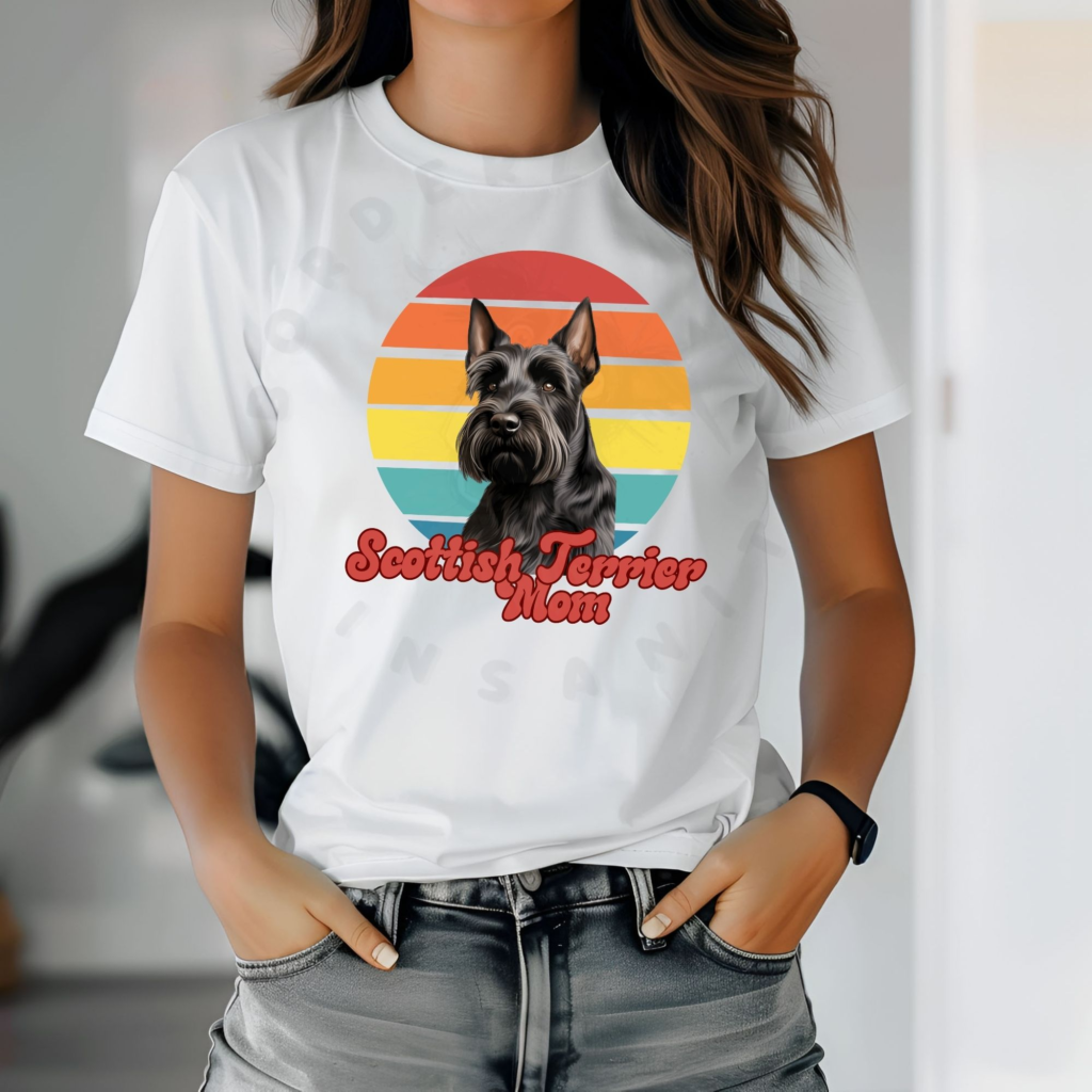 a woman wearing a white tee featuring a retro sunset design with a scottish terrier and the words scottish terrier mom in retro script