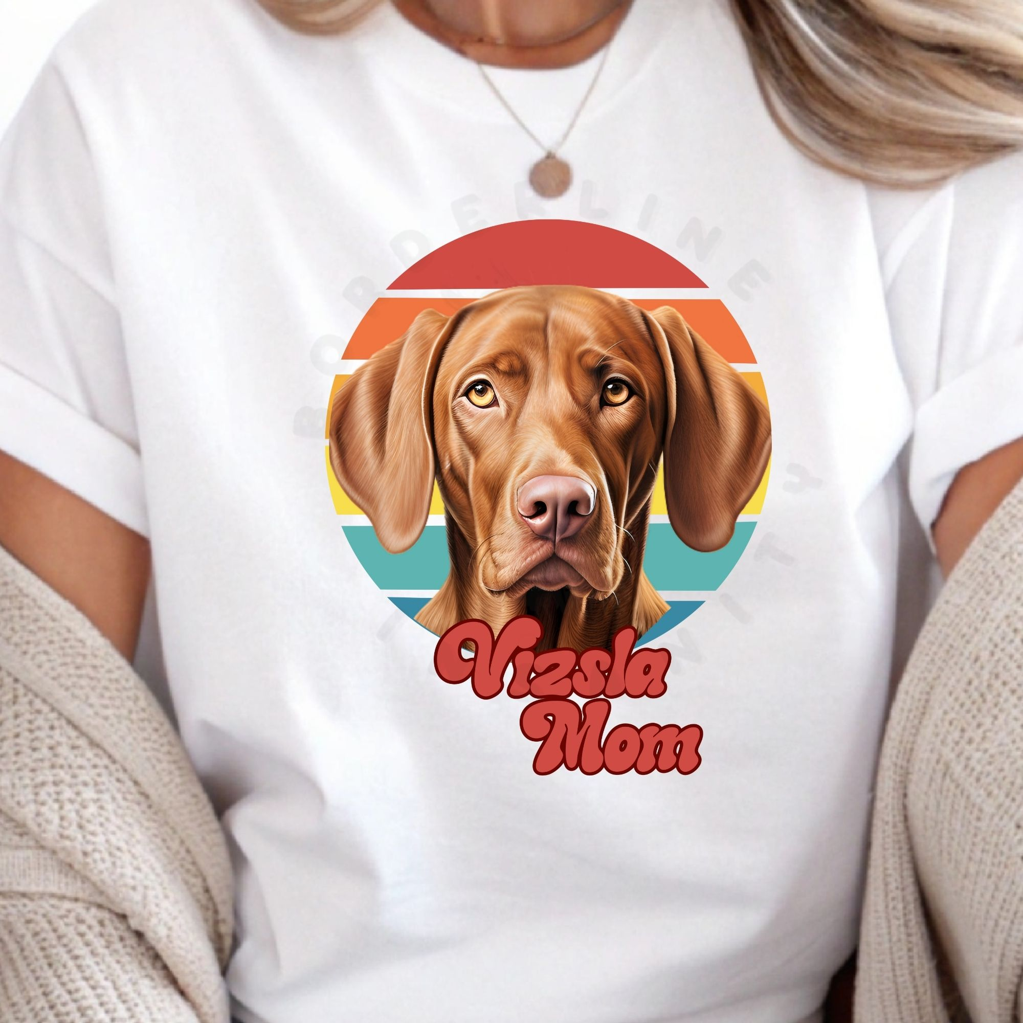 a woman wearing a white tee featuring a retro sunset design with a vizsla and the words vizsla mom in retro script