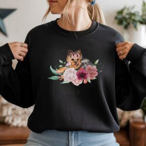 a woman wearing a black crewneck sweatshirt featuring an image of a yorkshire terrier in watercolor flowers