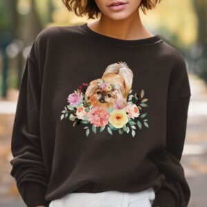 a woman in a park wearing a dark brown crewneck sweatshirt featuring an image of a pekingese in watercolor flowers