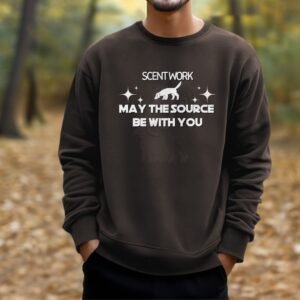 a man standing on a trail wearing a dark chocolate brown crewneck sweatshirt that says scent work may the source be with you with a graphic of a sniffing dog