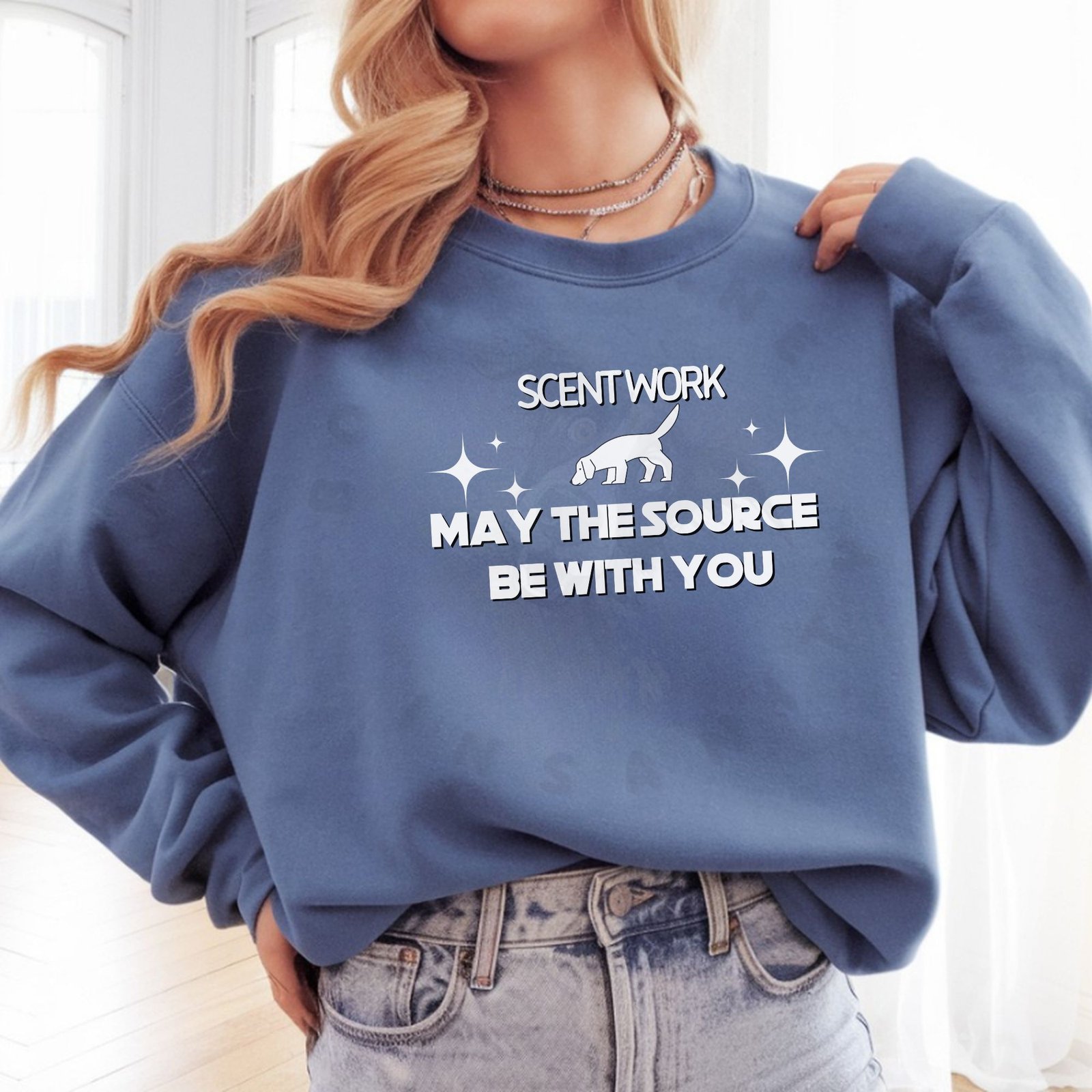 a woman leaning on a truck bed wearing a orange halloween sweatshirt that features 5 dogs dressed as ghosts with a crescent moon, jack-o-lanterns, and bats that says spooky season in cursive