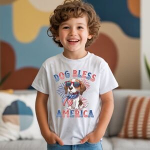 a boy wearing a white tee featuring a graphic of a cartoon style beagle wearing an american flag bandana with the words dog bless america in red and blue