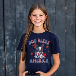 a girl wearing a navy tee featuring a graphic of a cartoon style boston terrier wearing an american flag bandana with the words dog bless america in red and blue