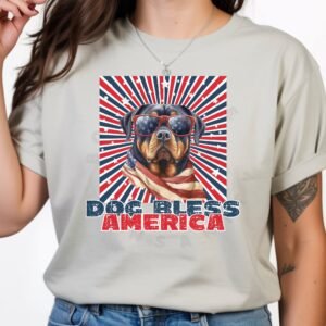 a woman wearing a silver tee with a patriotic background and an image of a Rottweiler in an american flag bandana and sunglasses that says dog bless america