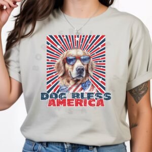 a woman wearing a silver tee with a patriotic background and an image of a golden retriever in an american flag bandana and sunglasses that says dog bless america